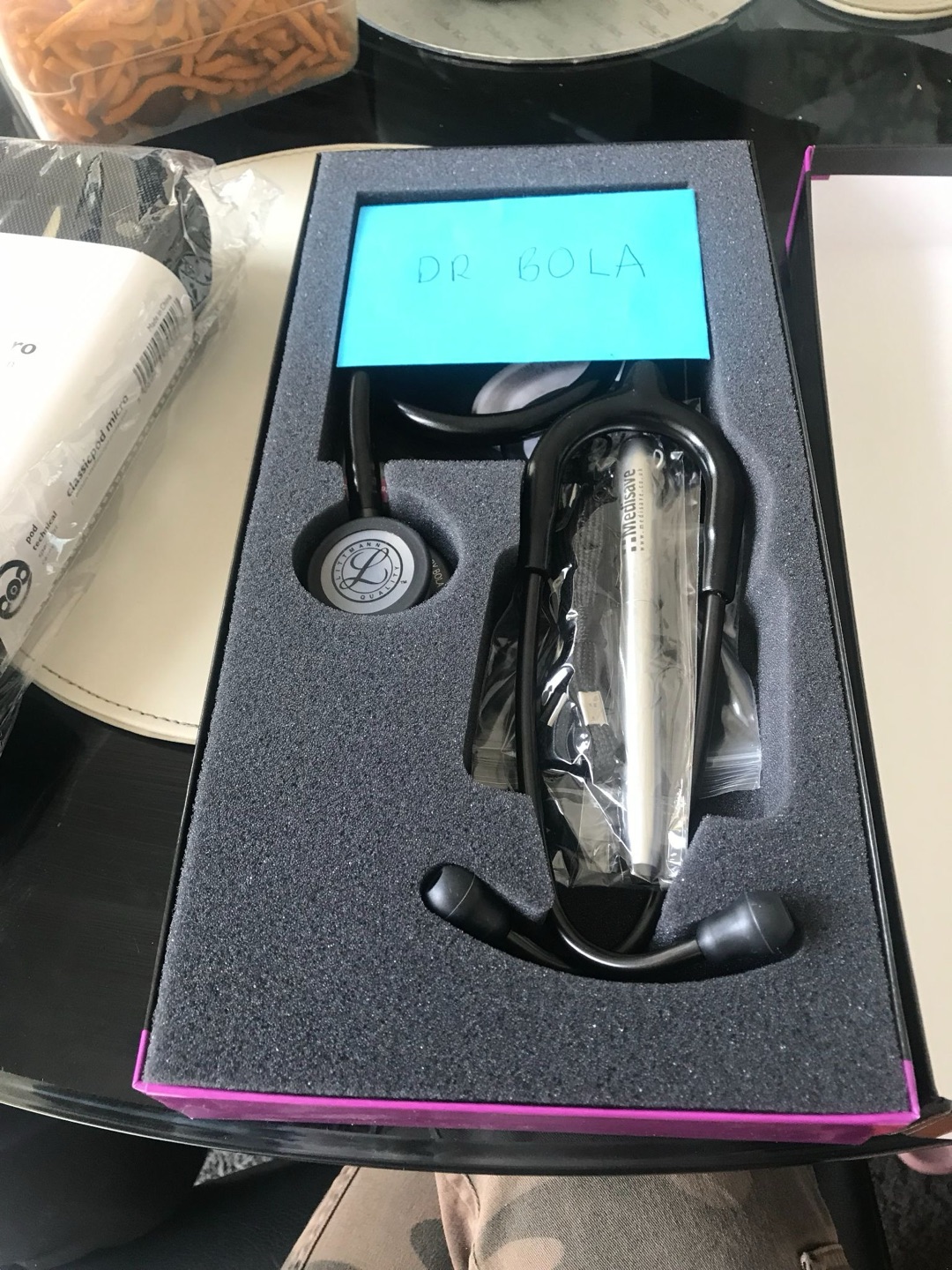 A boxed stethoscope and pen set with a handwritten note reading Dr Bola